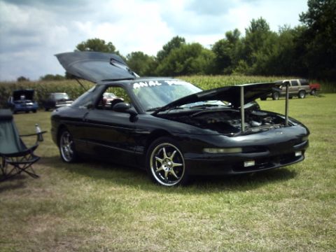 1995 Ford Probe - A black 1995 Ford Probe is displayed with its hood and trunk open at an outdoor event.