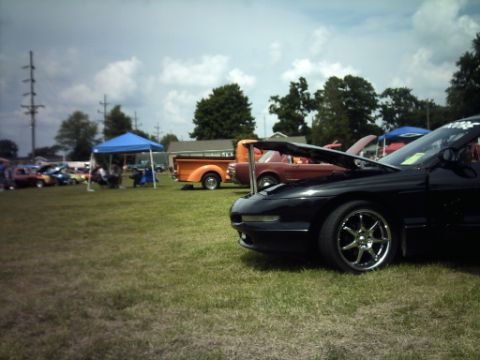 1995 Ford Probe - A black 1995 Ford Probe is displayed with its hood open at an outdoor car show.
