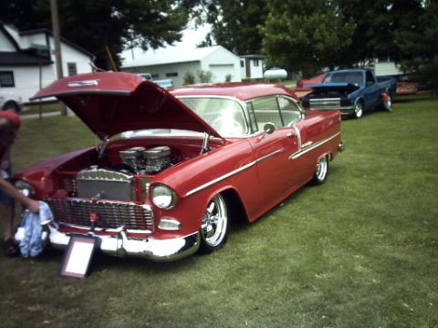 1995 Ford Probe - A red 1955 Chevrolet Bel Air coupe is displayed with its hood open, alongside a blue pickup truck.