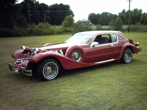 Red custom car with a spare tire mounted on the driver's side fender