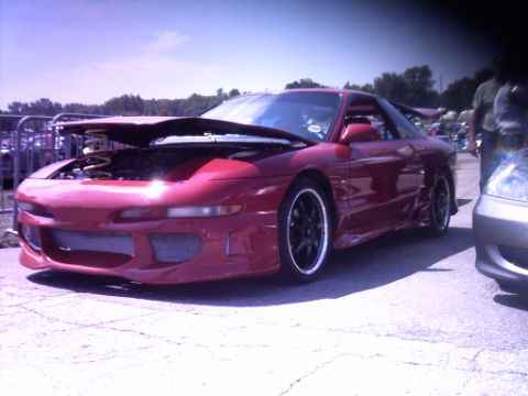 1995 Ford Probe - A red sports car is parked with its hood open at an outdoor event.