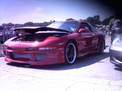 red sports car with hood open, parked next to another car