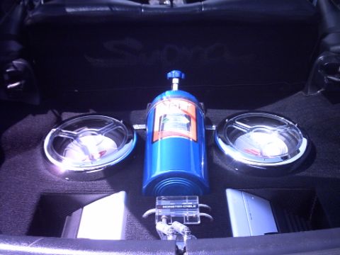 1995 Ford Probe - The trunk of a car is outfitted with a custom audio system, including speakers, amplifiers, and a nitrous oxide tank.