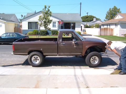 1985 Ford Ranger - A lifted 1985 Ford Ranger pickup truck with off-road tires is parked on a residential street.