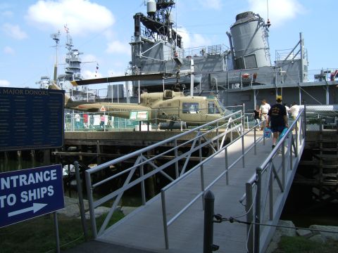 1998 Ford Taurus - A military helicopter is displayed on a ship, with visitors walking up a ramp to board.