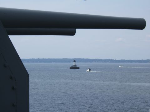 1998 Ford Taurus - A large gun barrel dominates the foreground of this scene, with a lighthouse and a boat visible on the water.