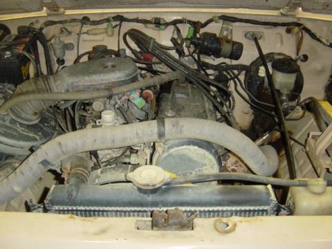 1987 Suzuki Samurai - The engine compartment of a vehicle, showing various components and wiring.
