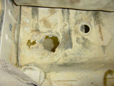1987 Suzuki Samurai - This photo shows significant rust and holes in the undercarriage of a vehicle, indicating structural damage.