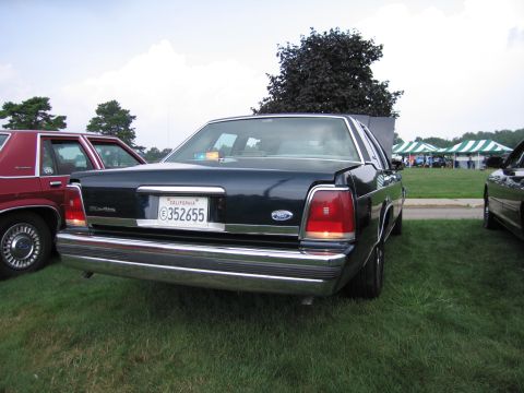 1991 Ford LTD Crown Victoria - Rear of a dark Ford full-size sedan on grass displaying a California license plate reading 352655.