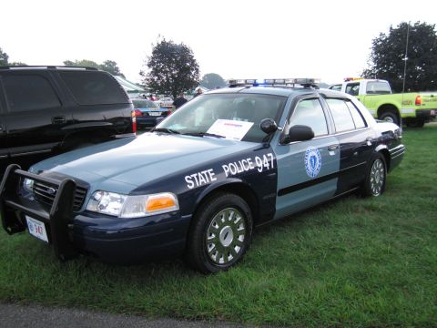 1991 Ford LTD Crown Victoria - blue-and-gray Ford Crown Victoria marked State Police 947 with push bar and light bar at a show field.