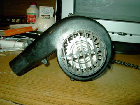 1990 Mitsubishi Eclipse - A blower motor part is shown on a desk, with a computer monitor and various items in the background.