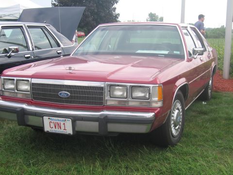 1991 Ford LTD Crown Victoria - Front view of a red Ford full-size sedan with chrome grille and a Massachusetts CVN 1 vanity plate on grass.
