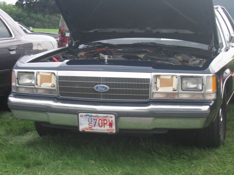 1991 Ford LTD Crown Victoria - Front of a dark Ford full-size sedan with its hood raised and a Massachusetts plate reading US 70PW.