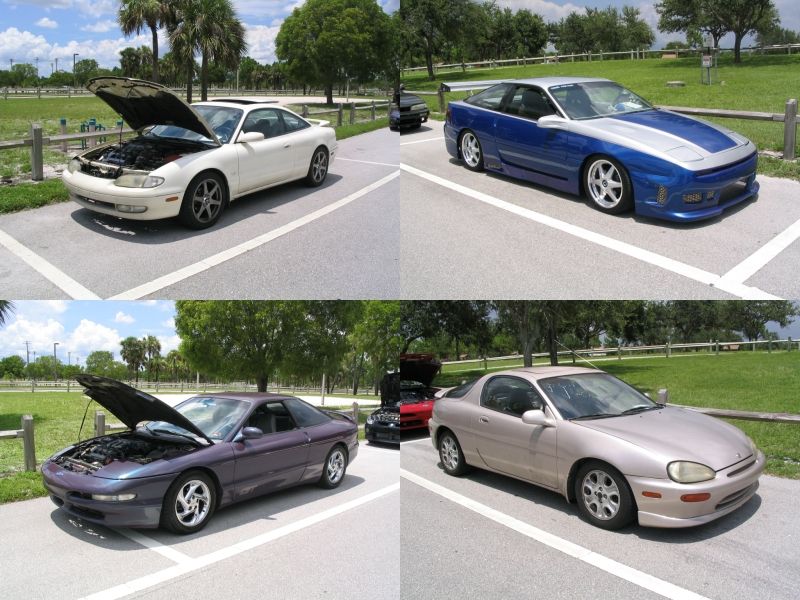 Four cars parked in a lot: a white coupe with hood up, a blue and silver coupe, a purple coupe with hood up, and a tan hatchback