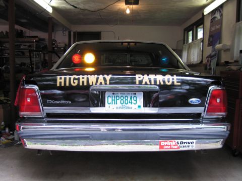 1991 Ford LTD Crown Victoria - Close rear view of a black Ford LTD Crown Victoria lettered Highway Patrol with a New Hampshire plate reading CHP8849.