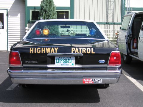 1991 Ford LTD Crown Victoria - Rear view of a black Ford LTD Crown Victoria police car with HIGHWAY PATROL lettering, a roof light bar, and a New Hampshire plate reading…