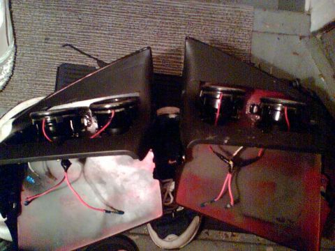 1997 Ford Probe - Two car door panels, each with two speakers and exposed wiring, are laid out on a carpeted surface.