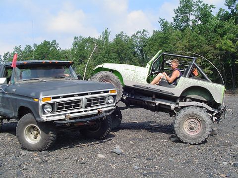 1979 Ford Bronco - A 1977 Ford F-Series truck is parked next to a modified Jeep, both appearing to be off-road vehicles.