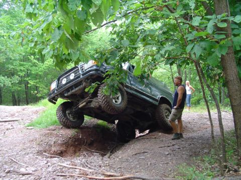 1979 Ford Bronco - This truck is attempting to navigate a challenging off-road obstacle, with its tires angled precariously.