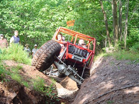 1979 Ford Bronco - Custom off-road buggy navigates a challenging muddy terrain with onlookers present.