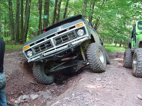 1979 Ford Bronco - This 1979 Ford Bronco navigates a challenging off-road course, with a green Jeep visible in the background.