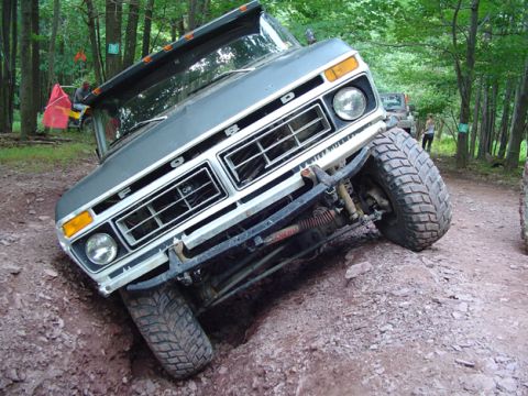 1979 Ford Bronco - Ford Bronco tackling an off-road obstacle on a dirt trail.