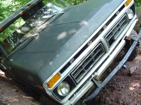 1979 Ford Bronco - This Ford truck's grille and headlights are visible, with the word 'FORD' spelled out across the front.