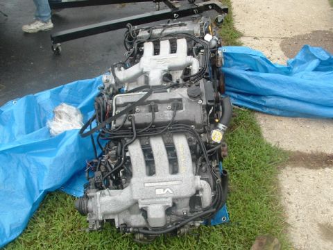 1996 Ford Probe - A V6 engine is laid out on a blue tarp, ready for installation or removal. A stand is visible in the background.