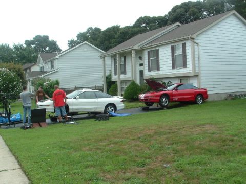1996 Ford Probe - Two 1996 Ford Probes are parked in a driveway with their hoods open, suggesting maintenance or an engine swap is underway.