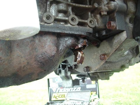 1996 Ford Probe - Close-up of an engine oil filter and a damaged bracket on an engine block.