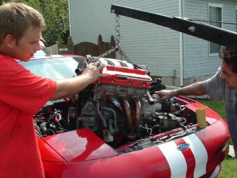1996 Ford Probe - Engine being installed into a 1996 Ford Probe with assistance from an engine hoist.