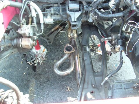 1996 Ford Probe - Close-up view of a car's engine bay, focusing on the exhaust manifold and surrounding mechanical parts.