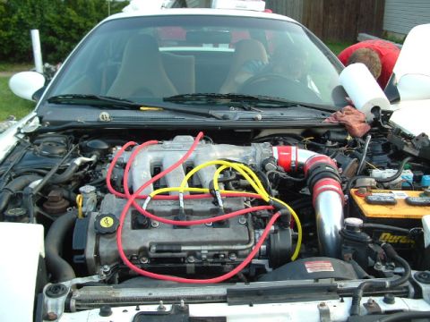 1996 Ford Probe - The engine bay of a white car is shown with various engine components and wiring visible.