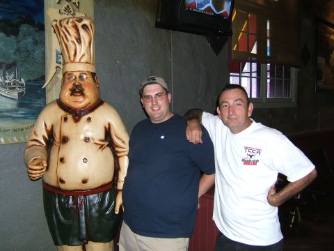 1998 Ford Taurus - Two men pose with a large chef statue in what appears to be a restaurant or bar.