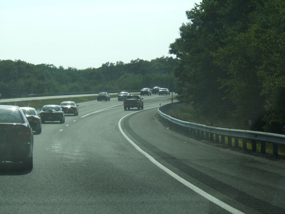 Highway scene with multiple cars driving on a sunny day