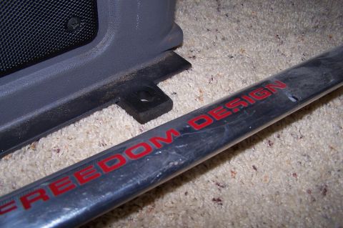 1997 Ford Probe - A close-up shows a car's interior trim and a metal bar with the words "FREEDOM DESIGN" in red lettering.