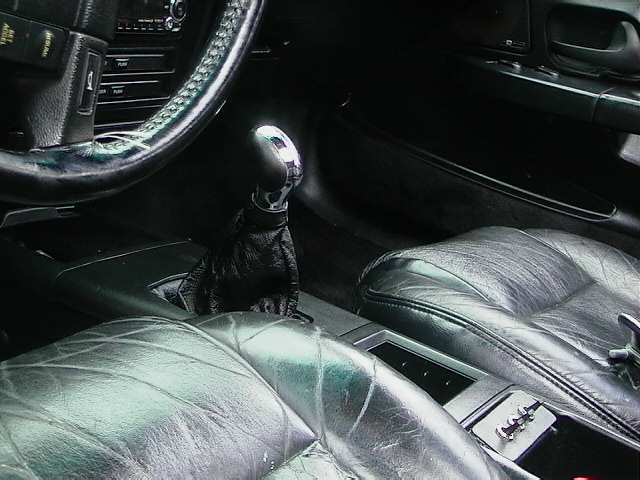 car interior showing leather seats, steering wheel, and chrome gear shifter