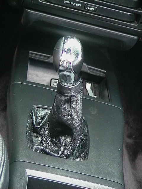 1992 Ford Taurus - Close-up of an automatic gear shifter with a leather boot and chrome knob.
