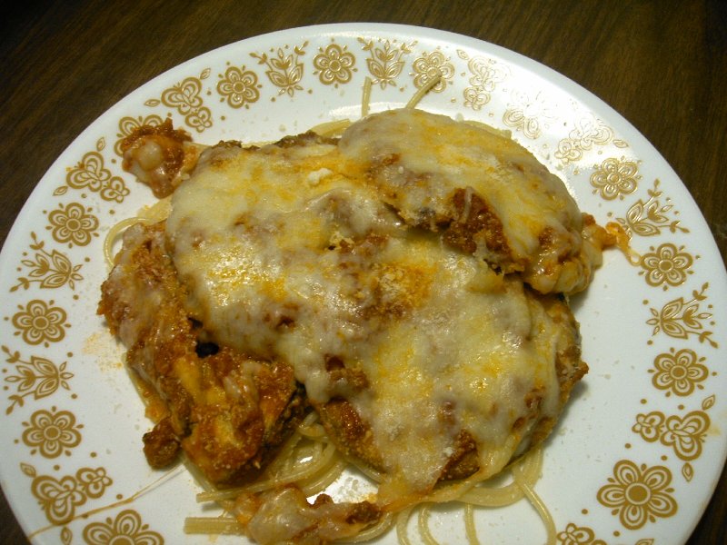 Plate of spaghetti topped with meat sauce and melted cheese