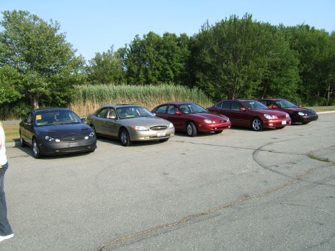1998 Ford Taurus - Several Ford Taurus sedans are parked in a lot on a sunny day.
