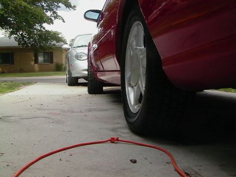 1992 Ford Taurus - Two cars parked side-by-side on a concrete driveway, with a red car in the foreground.