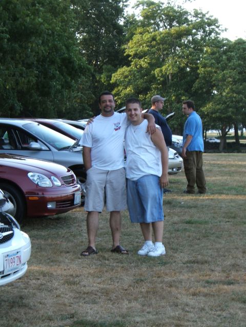1998 Ford Taurus - A gathering of people and vehicles takes place outdoors on a sunny day.
