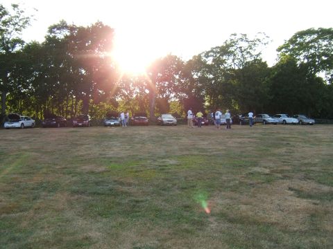1998 Ford Taurus - Several cars are parked in a field during a sunny day gathering.