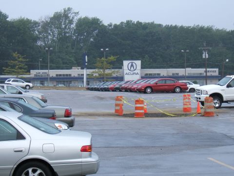 1998 Ford Taurus - A red sedan is parked in a lot in front of an Acura dealership.