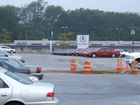 1998 Ford Taurus - Cars are parked in a lot outside an Acura dealership under a cloudy sky.