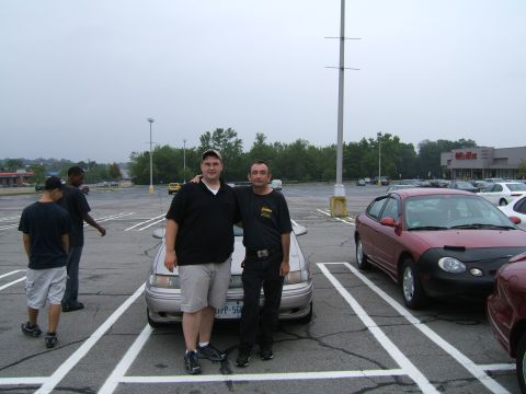 1998 Ford Taurus - Two men pose for a photo in a parking lot with multiple vehicles visible.