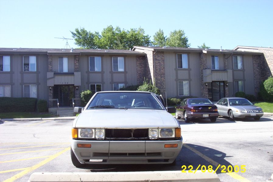 Silver sedan with a damaged front grille and bumper, parked in a lot