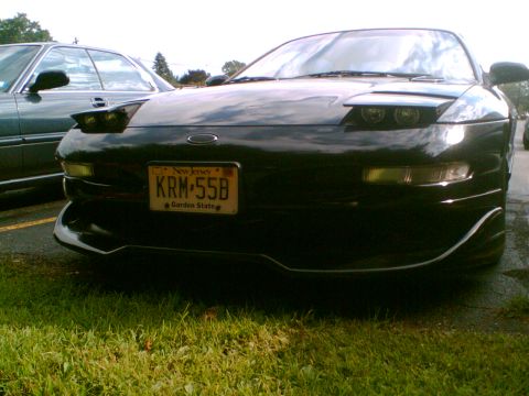 1997 Ford Probe - Front view of a black car with pop-up headlights and a New Jersey license plate.