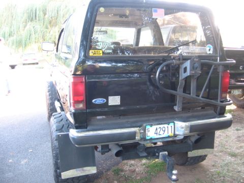 1991 Ford Explorer - This black Ford Bronco, likely a 1991 model based on its body style, is seen from the rear with a spare tire carrier and a visible license…