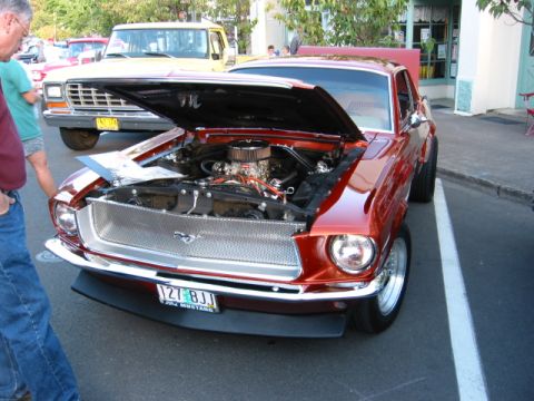 1991 Ford Explorer - A classic orange Mustang is displayed with its hood open, revealing the engine compartment.